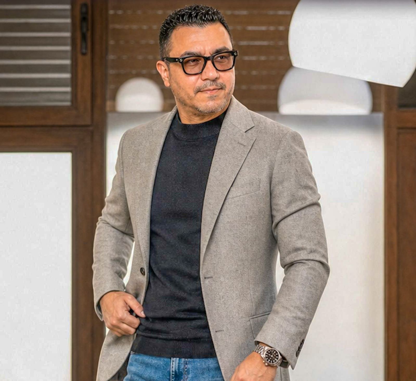 Rafael Castro in a gray blazer and black sweater, looking to the side